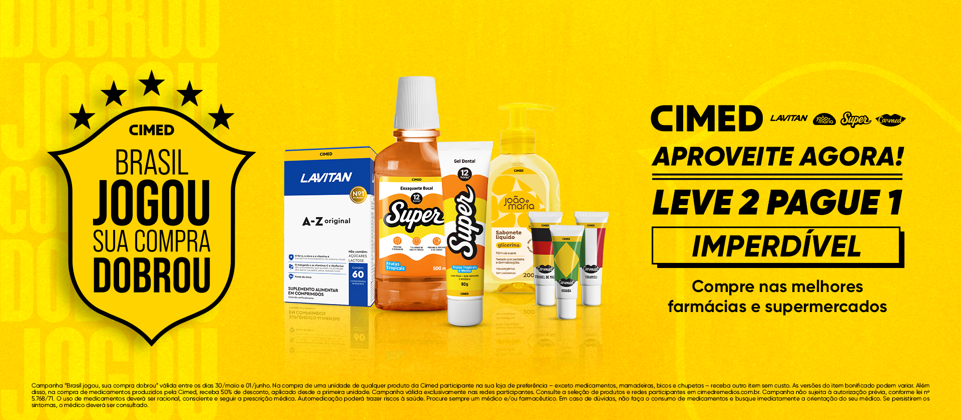 Banner promocional da Cimed com fundo amarelo. À esquerda, um escudo preto com cinco estrelas e o texto 'Cimed: Brasil jogou, sua compra dobrou'. No centro, uma vitrine com produtos da marca, incluindo Lavitan A-Z, enxaguante e gel dental Super, sabonete líquido João e Maria e protetores labiais Carmed. À direita, o texto em destaque: 'Aproveite agora! Leve 2 pague 1 Imperdível. Compre nas melhores farmácias e supermercados'